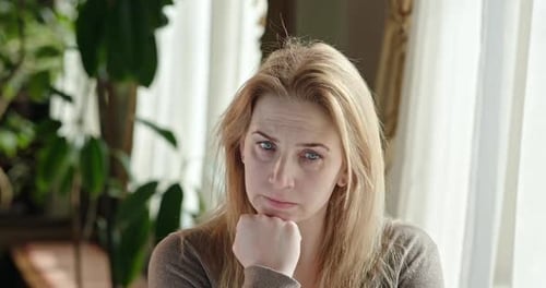 Woman Ponders and Signals for Silence Indoors