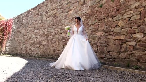 Elegant Bride in White Dress with Bouquet Posing
