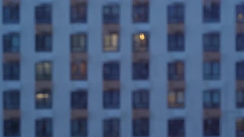 Rain Drops Flow Down Window Glass on Background of Windows House on Evening