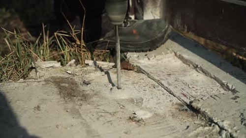 Builder Drills a hole in the wall with a Hammer Drill. Close-up of hammer drill perforator making ho