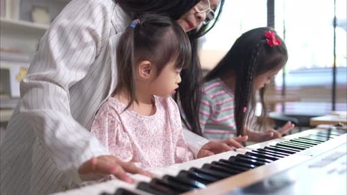 Woman Teaching Piano to Children in Home
