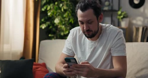 Man Using Phone on Couch in Living Room
