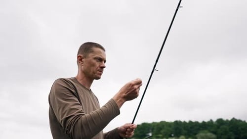 Fly fisherman male hands with fishing rod or spinning in hands feeder free style method