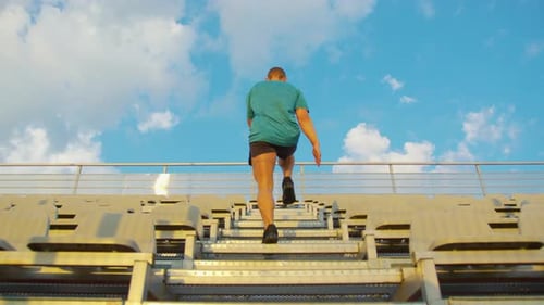 Man Walking Up Stairs Outside on Sunny Day