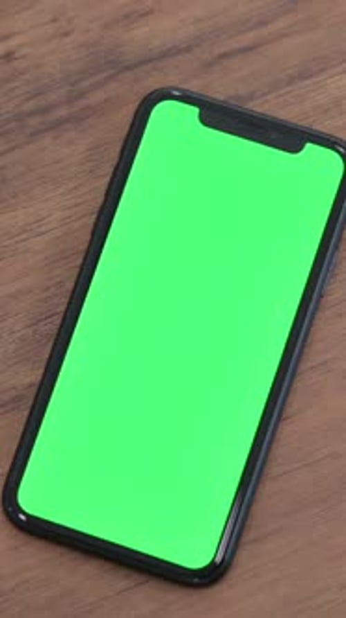 Finger Taps Green Screen Mobile Phone on Table