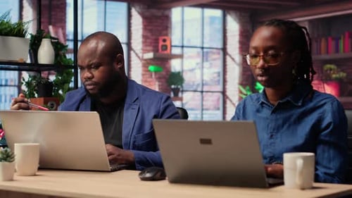 African American Man and Woman Sit at a Stylish Home Office