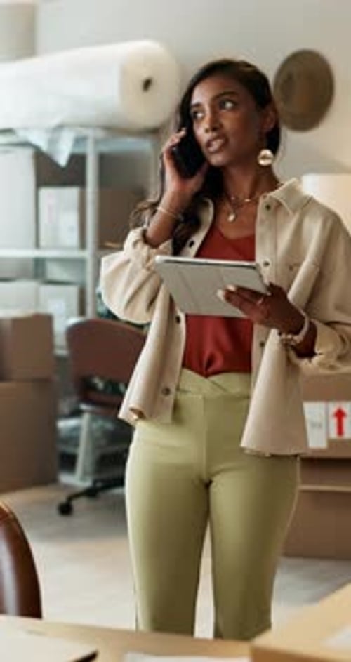 Woman on Phone With Tablet in Home Office