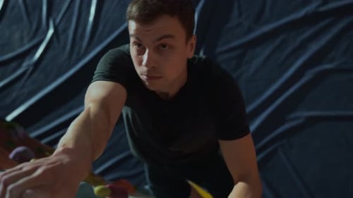 Male Rock Climber Ascending Indoor Climbing Wall