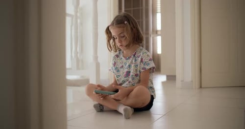 Girl Sits on Floor Using Mobile Phone