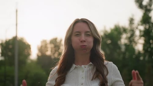 Elegante madre asomando las mejillas mientras sonríe en una excursión de picnic