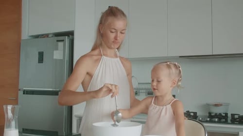 Woman and Child Cooking Together in Kitchen