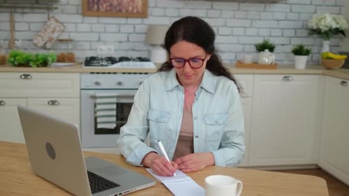 Woman Working at Home at Kitchen Table