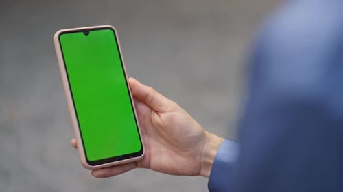 Arm Holding Green Mobile Phone in Office Closeup Manager Videocalling Partner