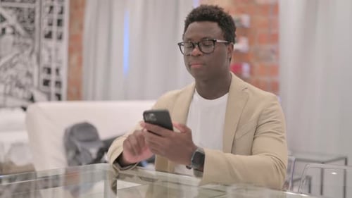 Young Adult Talking on Smartphone Indoors