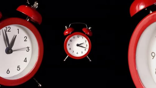 Fast Moving Red Alarm Clocks on Black Background Animation
