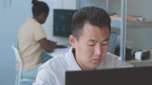 Asian Man Working on Computer in Office