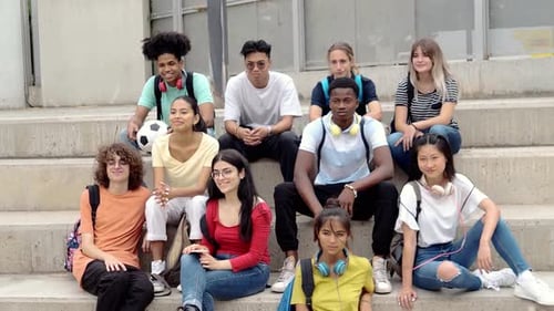 Group of Teenage Multiethnic Students Sitting on a High School Stairs Looking at Camera