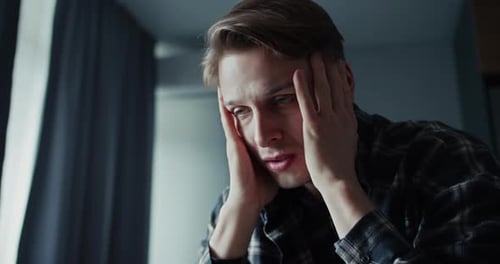 Upset Desperate Man Rubbing His Temples at Home