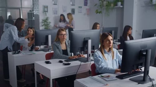 Escritório de uma empresa de TI moderna com equipe de trabalhadoras Mulheres inteligentes trabalhando com computadores