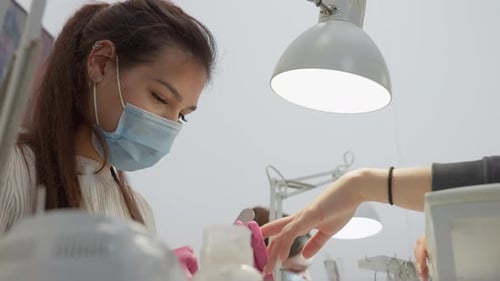 Woman Manicurist Working on Client's Nails in Salon