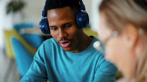 Une femme et un homme discutent d'un projet collaboratif en ligne sur leur lieu de travail