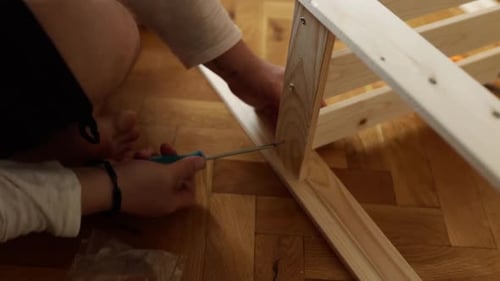 Man Assembling New Wooden Shelf and Furniture in the Apartment
