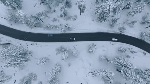 Capturing a Breathtaking Aerial View of SnowCovered Road with Vehicles