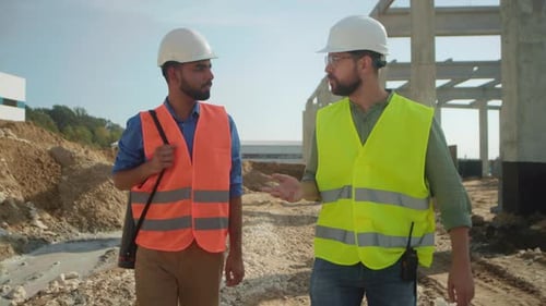 Construction Workers Discuss Project on Building Site