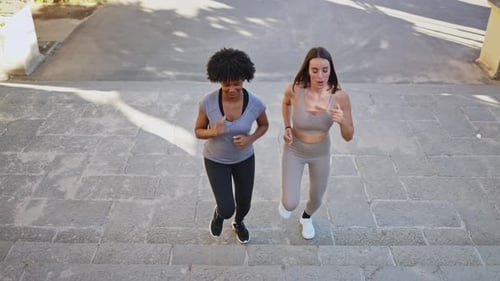 Women Running Up Steps in City