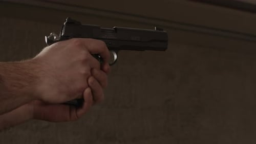 Pistole zielt und mehrere Schüsse auf dem Schießstand abgibt.