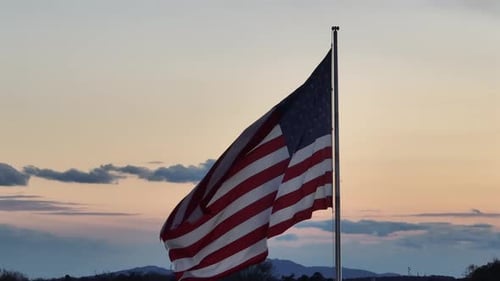 American Flag Waving Against Purple Sunset Sky