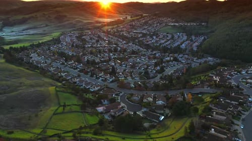 Drone shot over Suburban California neighborhood in between hills.