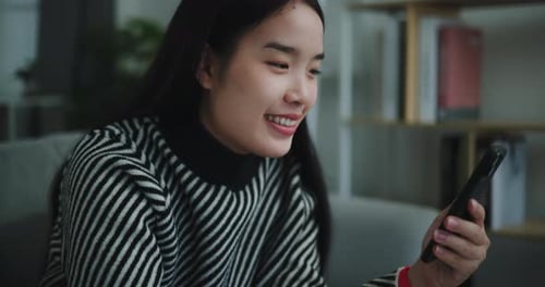 Young Woman Using Phone While Drinking Indoors