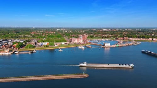 Empty barge moving slowly by the lake waterscape of Lelystad, the Netherlands.
