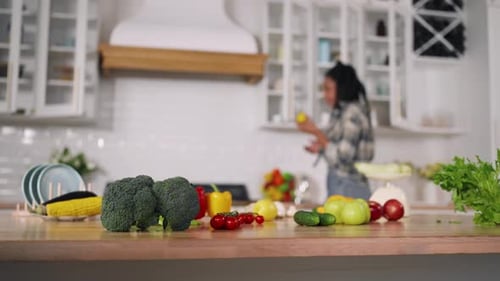 Woman Gathering Vegetables in Bright Kitchen