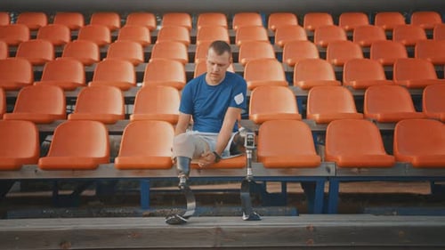 Athletic Disabled Fit Man with Prosthetic Running Blades is Preparing for a Training on an Outdoor