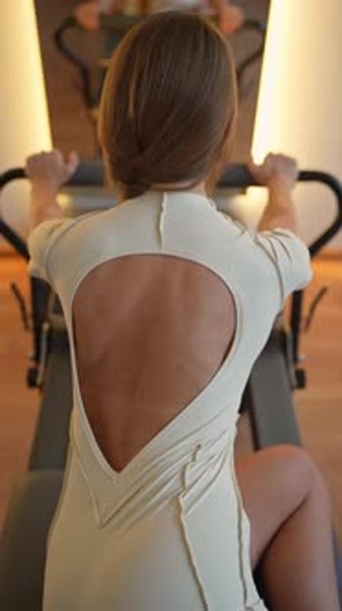 Woman Exercising on Pilates Machine for Fitness