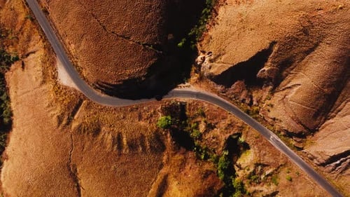 Aerial Perspectives Highlight a Sleek Black Car Navigating a Twisting Road Through Madagascar's
