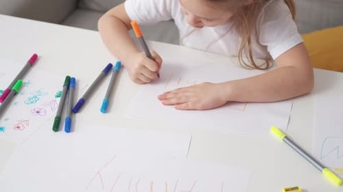 Young Girl Drawing Family with Markers at Home