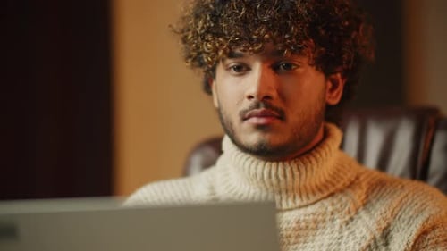 Curly Bearded Student Studying Online Young Man Blinking While Reading From Laptop Screen Freelancer