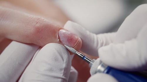 Manicurist Using Electric File on Fingernail