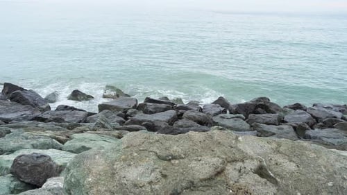 Sea waves hit the rocky shore creating splashes. Calmness and tranquility, meditation and relax