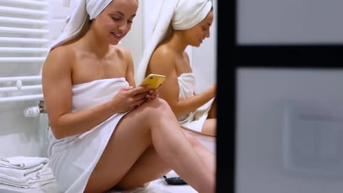 Young Woman Using Phone in Bathroom Towel