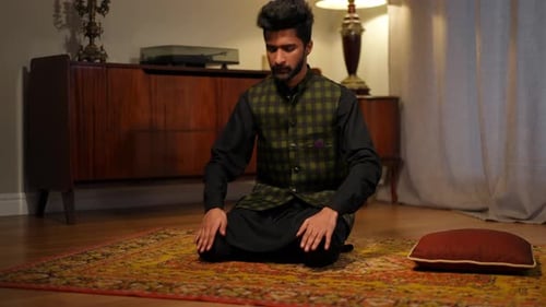 Man Kneeling in Prayer on Rug in Home