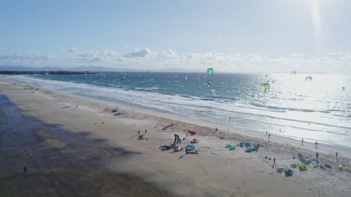 Kiters in the Ocean and on the Beach