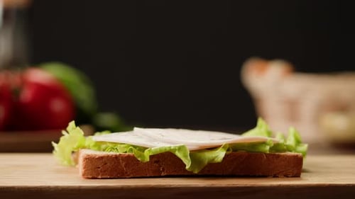 Preparing a Sandwich with Lettuce, Ham, and Cheese