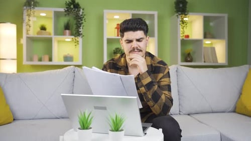 Focused Young Adult Working with Laptop at Home