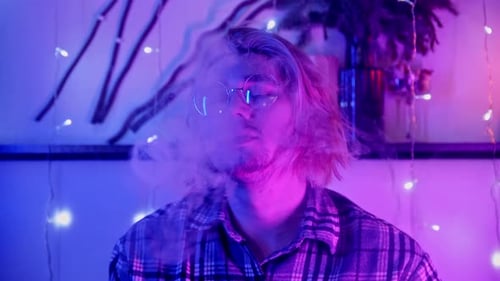 Young Adult with Blond Hair Vaping Indoors