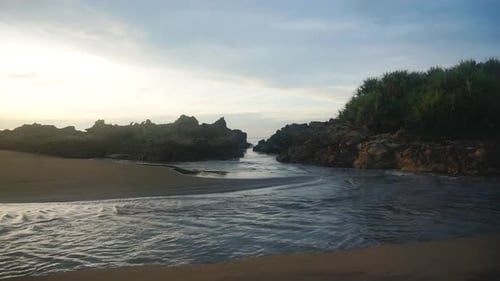 beautiful view of the sunrise on the beach with small waves, morning natural panorama