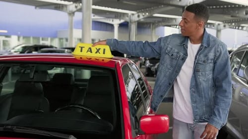 Man Places Taxi Sign on Car and Smiles